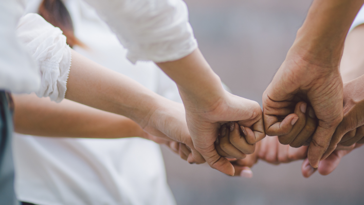 group of peoples fists in a circle