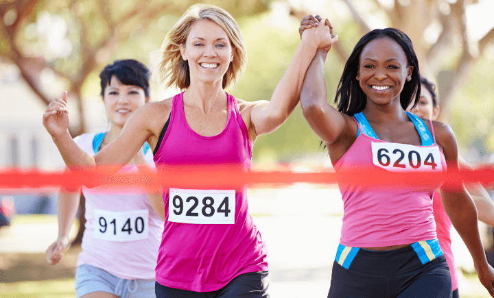 women crossing a race finish line