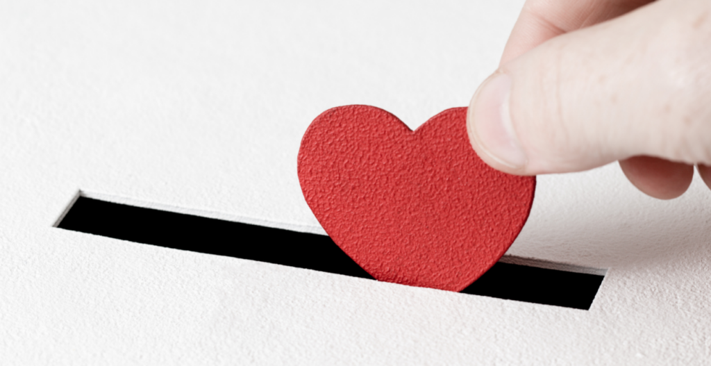 person puts heart coin in slot