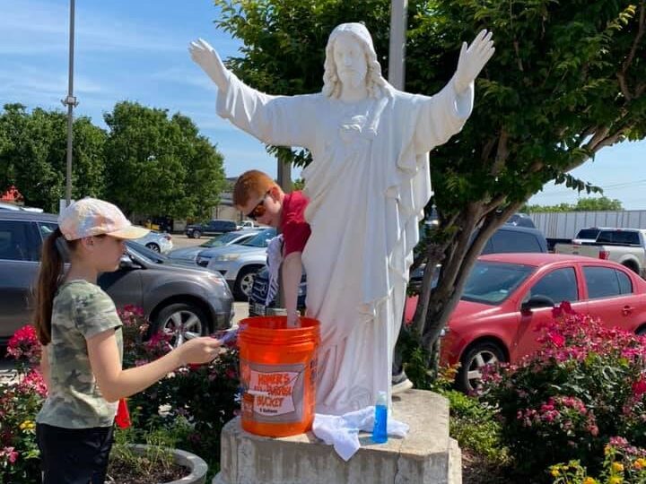 Kids cleaning Jesus statue at CCA