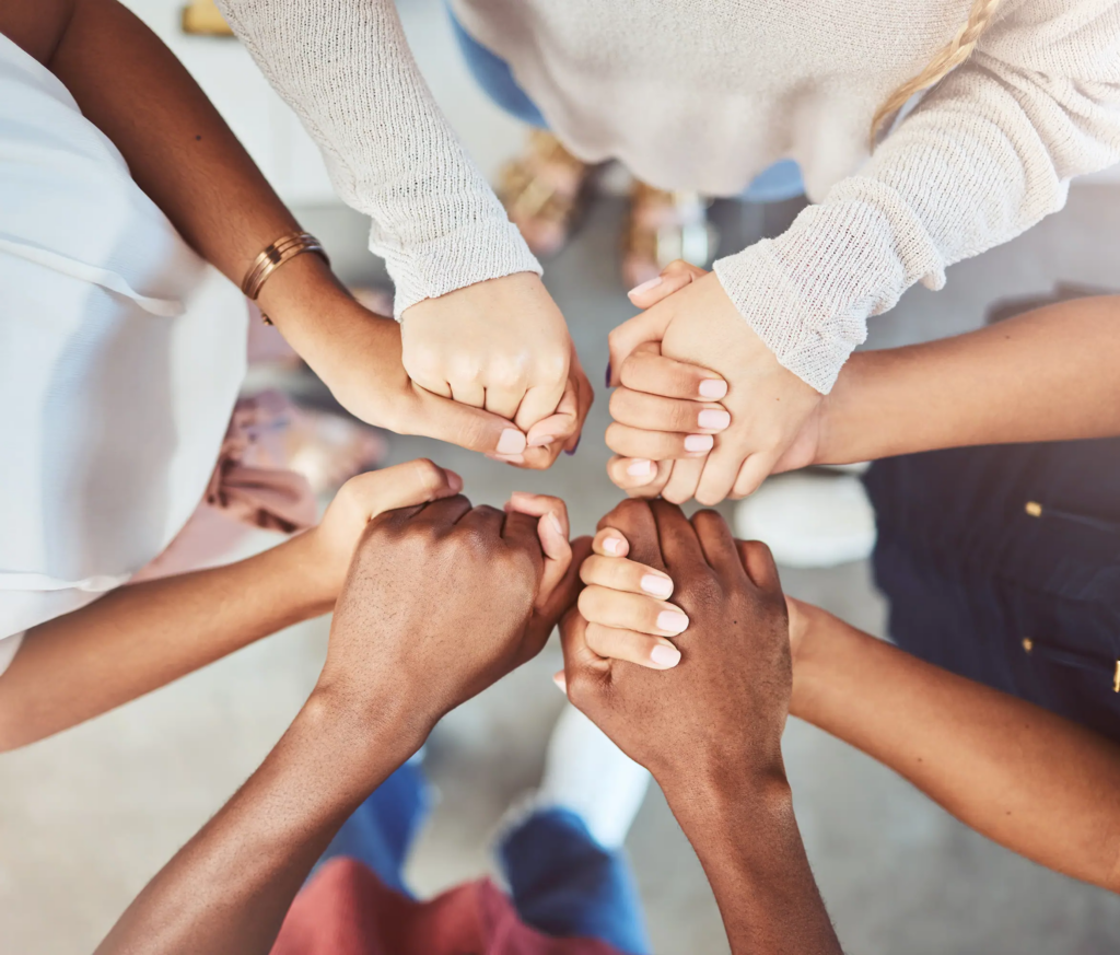 diverse group of people holding hands and supporting each other